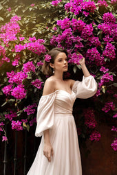 Gładka suknia ślubna w stylu księżniczki z bufiastym rękawem oraz lekką spódnicą z rozporkiem z pracowni sukien ślubnych Dama Couture (zdjęcie główne)