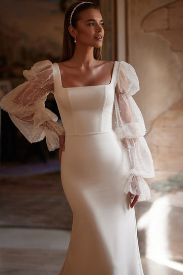 Minimalistyczna suknia ślubna w stylu syrenki z kwadratowym dekoltem, ozdobnymi rękawami oraz trenem z pracowni sukien ślubnych Dama Couture (zdjęcie główne)