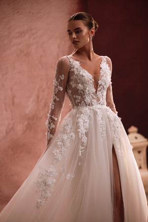 Suknia Semiramida z DAMA Couture ma przezroczysty gorset ozdobiony haftami i trójwymiarowymi, kwiatowymi aplikacjami — efekt romantyzmu i eterycznego piękna.