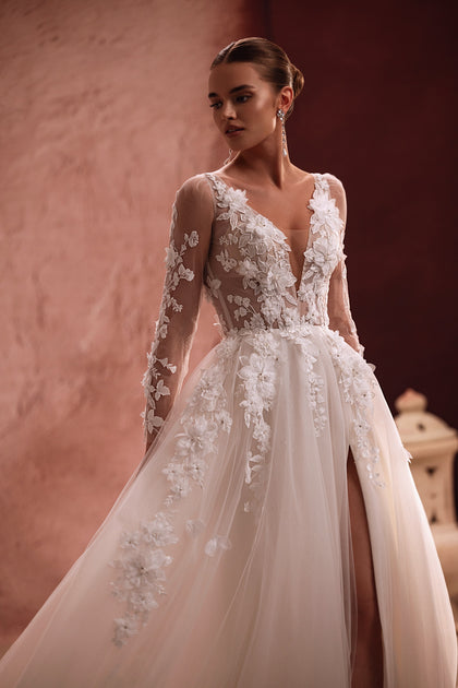 Suknia Semiramida z DAMA Couture ma przezroczysty gorset ozdobiony haftami i trójwymiarowymi, kwiatowymi aplikacjami — efekt romantyzmu i eterycznego piękna.