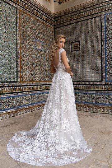 Romantyczna suknia ślubna w stylu księżniczki ozdobiona kwiatową koronką z krótkim rękawem oraz wiązaniem na plecach z pracowni sukien ślubnych Dama Couture (zdjęcie główne)