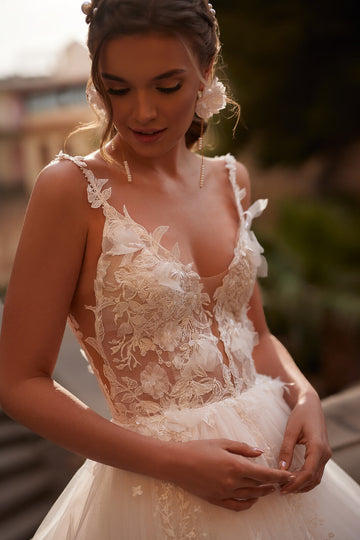 Kobieca suknia ślubna w stylu glamour z głębokim dekoltem na ramiączkach oraz lekką spódnicą z koronkowym trenem z pracowni sukien ślubnych Dama Couture (zdjęcie przód)