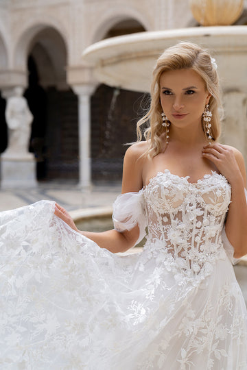 Kobieca suknia ślubna w stylu księżniczki z opadającymi ramiączkami oraz bogato zdobionym gorsetem i spódnicą z koronki 3D z pracowni sukien ślubnych Dama Couture (zdjęcie przód)