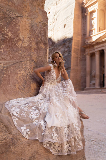 Modna suknia ślubna w stylu księżniczki z krótkim rękawem i finezyjnym dołem, cała wykończona kwiatową koronką 3D z trenem z pracowni sukien ślubnych Dama Couture (zdjęcie bok)