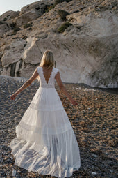 Romantyczna suknia ślubna w stylu boho wykończona rustykalną koronką na szerokich ramiączkach oraz zwiewną spódnicą z pracowni sukien ślubnych Dama Couture (zdjęcie tył)