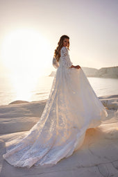 Romantyczna suknia ślubna w stylu księżniczki z długim, bufiastym rękawem oraz spódnicą z koronkowym trenem z pracowni sukien ślubnych Dama Couture (zdjęcie główne)