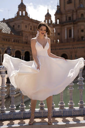 Tania suknia ślubna w  gładkim stylu na ramiączkach oraz ze spódnicą midi z pracowni sukien ślubnych Dama Couture (zdjęcie główne)