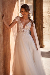 Romantyczna suknia ślubna z dekoltem i krótkim rękawkiem z fruwajkami oraz tiulową spódnicą z pracowni sukien ślubnych Dama Couture (zdjęcie główne)