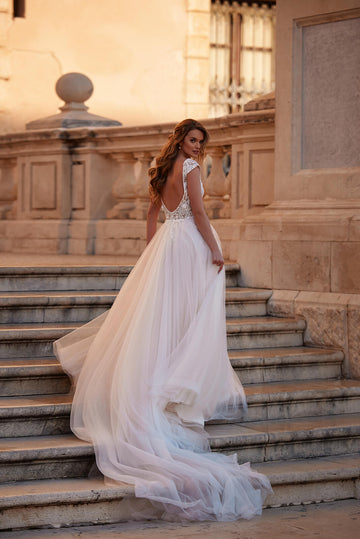 Kobieca suknia ślubna w stylu glamour w odcieniach beżu, wykończona koronką 3D oraz krótkim rękawkiem i zwiewną spódnicą z trenem z pracowni sukien ślubnych Dama Couture (zdjęcie tył)