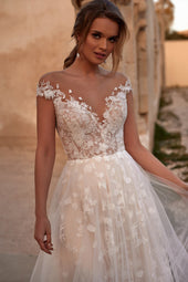 Romantyczna suknia ślubna ozdobiona kwiatową koronką z opadającymi ramiączkami, głębokim dekoltem oraz delikatną spódnicą z trenem z pracowni sukien ślubnych Dama Couture (zdjęcie główne)