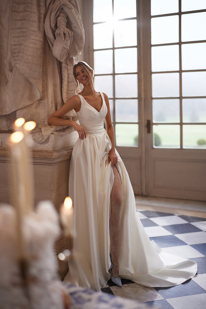 Elvira wedding dress – A-line bridal gown with an open V-neckline and clean draped skirt with a high slit.