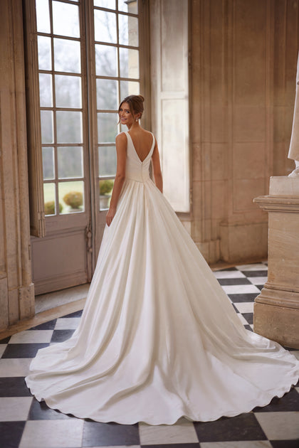 Elvira wedding dress from the Something Blue 2027 collection – an open V-neckline and clean draped skirt with a high slit.