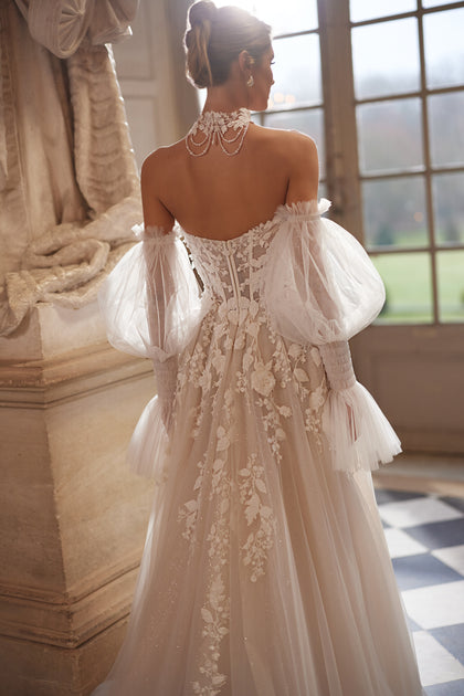 Estella wedding dress – a dimensional floral corset and voluminous off-the-shoulder sleeves.
