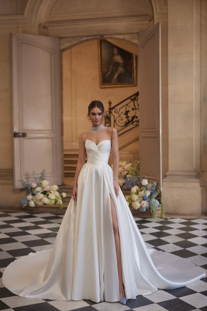 Lucienne wedding dress – A-line bridal gown with a crystal-embellished illusion neckline and draped satin skirt with a high slit.