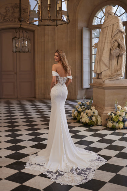 Matilde wedding dress – an off-the-shoulder neckline and lace-traced fitted silhouette.