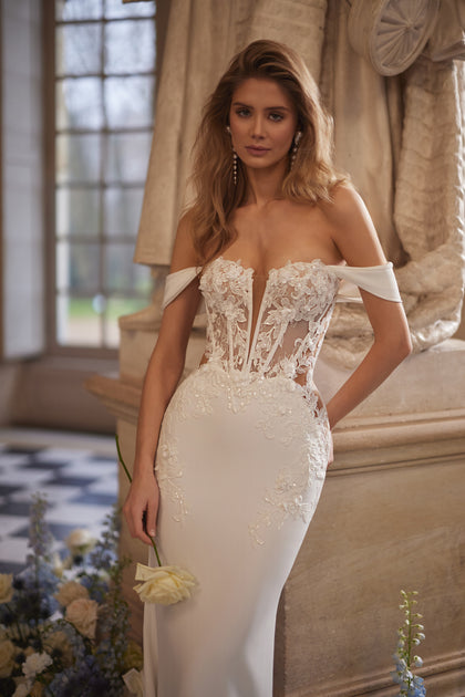 Matilde wedding dress – an off-the-shoulder neckline and lace-traced fitted silhouette, DAMA Couture Something Blue 2027.