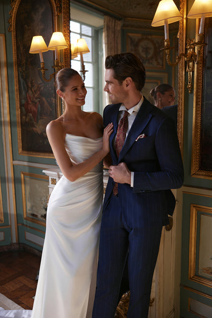 Sodden wedding dress – a softly draped strapless neckline and high slit in fluid satin.