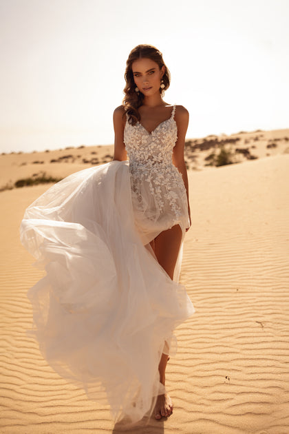 The Aviva bridal gown features a deep neckline and lace shoulder straps, blending elegance with romantic allure.