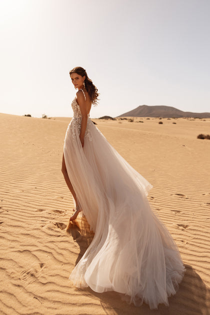 The Aviva bridal dress with a soft tulle train and elegant slit brings fluidity and charm to a modern bridal silhouette.