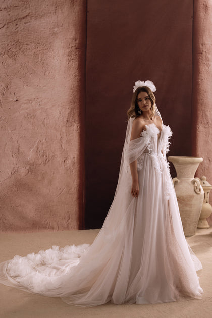 Tył sukni ślubnej Bella ukazuje powłóczysty tren z tiulu ozdobiony kwiatami 3D, który nadaje stylizacji bajkowego uroku.