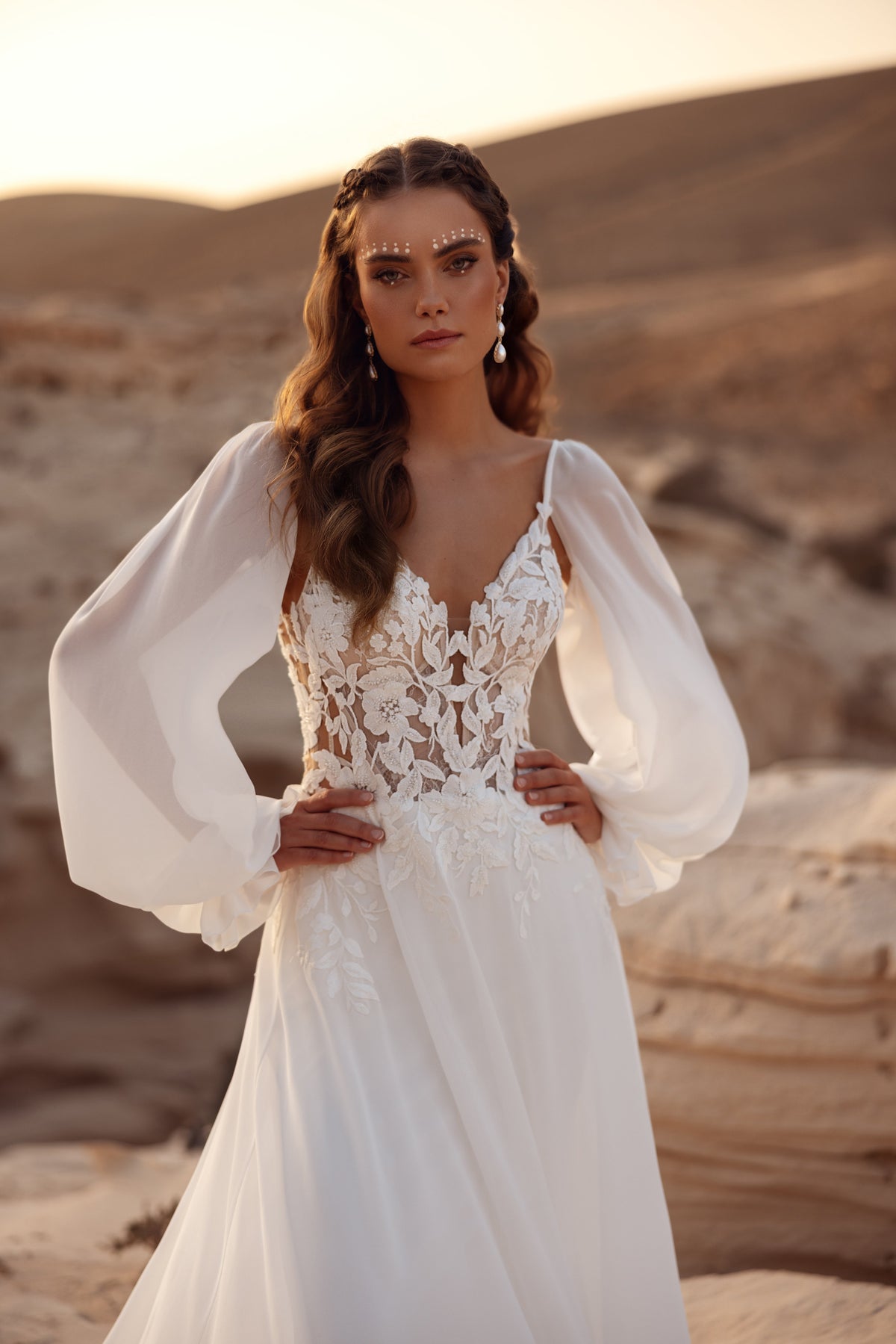 The Judith wedding dress features a lace bodice with airy chiffon sleeves, perfect for a romantic boho bride.