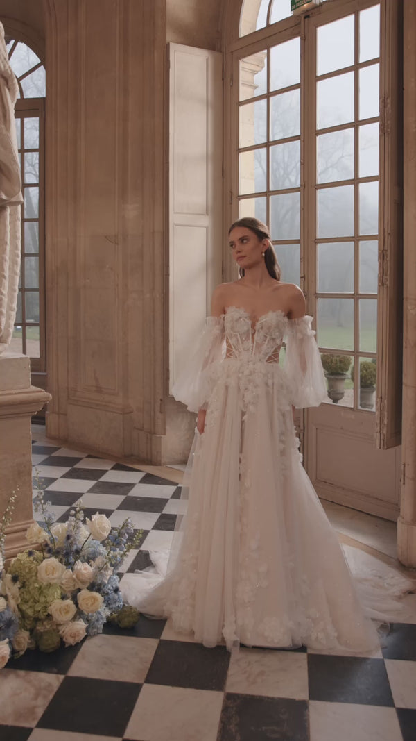 Video of the Celestine wedding dress in motion – A-line silhouette with an open neckline, airy off-the-shoulder sleeves and 3D florals.