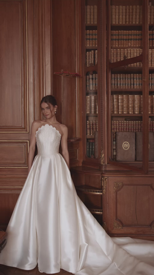 Video of the Shella wedding dress in motion – A-line silhouette with a sculpted strapless corset and full satin skirt.