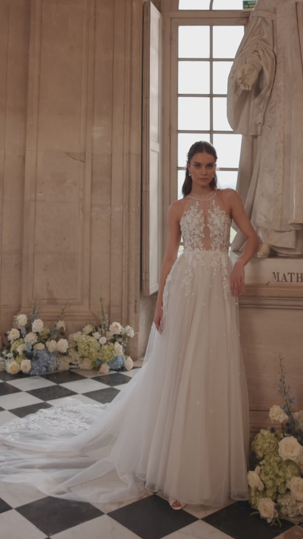Video of the Nilla wedding dress in motion – A-line silhouette with a sheer high neckline and floral lace tulle skirt.