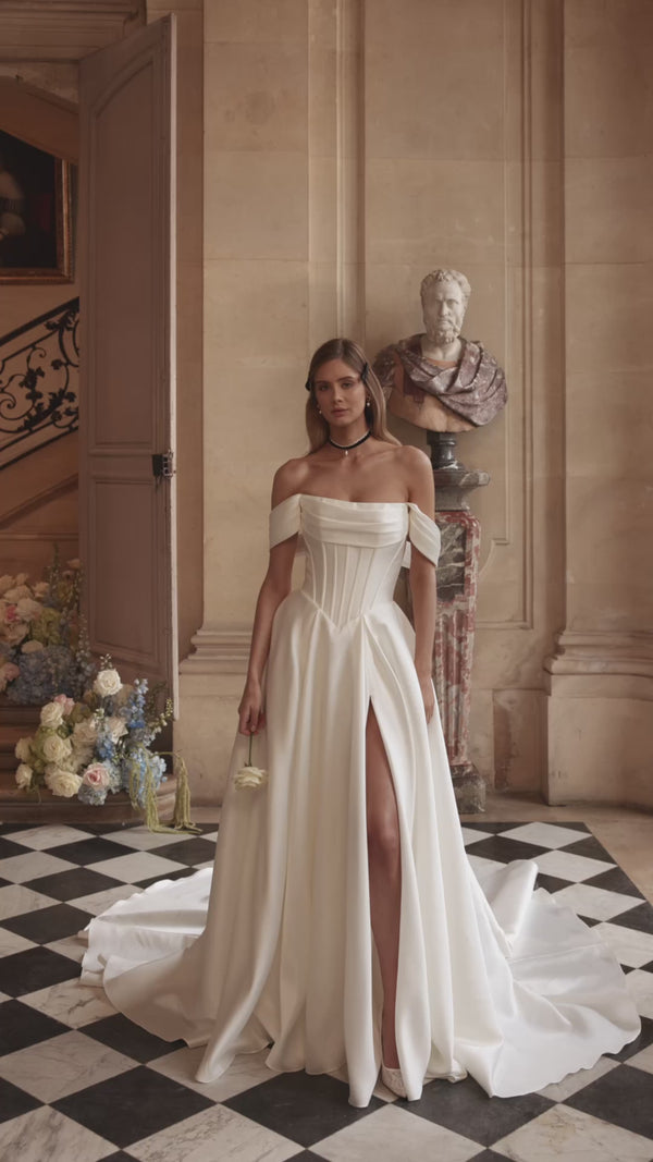 Video of the Alienor wedding dress in motion – A-line silhouette with draped off-the-shoulder sleeves and a clean satin skirt.