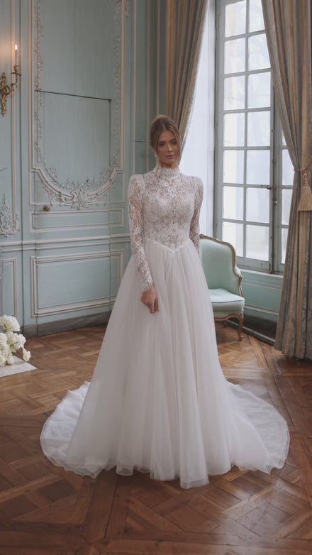 Video of the Tonia wedding dress in motion – A-line silhouette with a high neckline and long sheer lace sleeves.