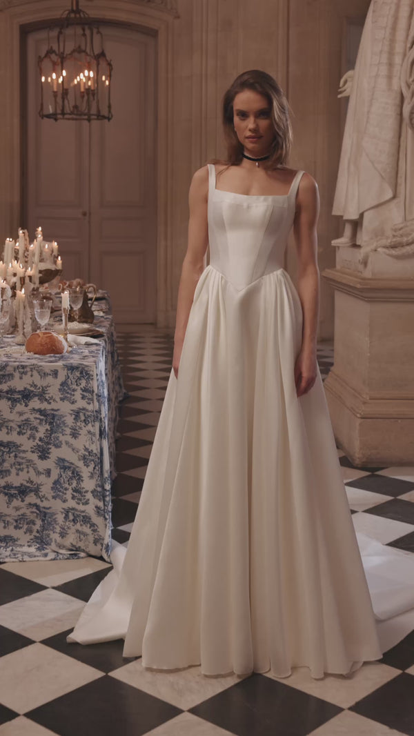 Video of the Aretuza wedding dress in motion – A-line silhouette with a clean square neckline, slender straps and full satin skirt.
