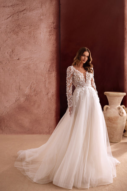 Suknia ślubna Shanin z długimi koronkowymi rękawami, głębokim dekoltem i tiulowym dołem zachwyca lekkością oraz romantycznym stylem.